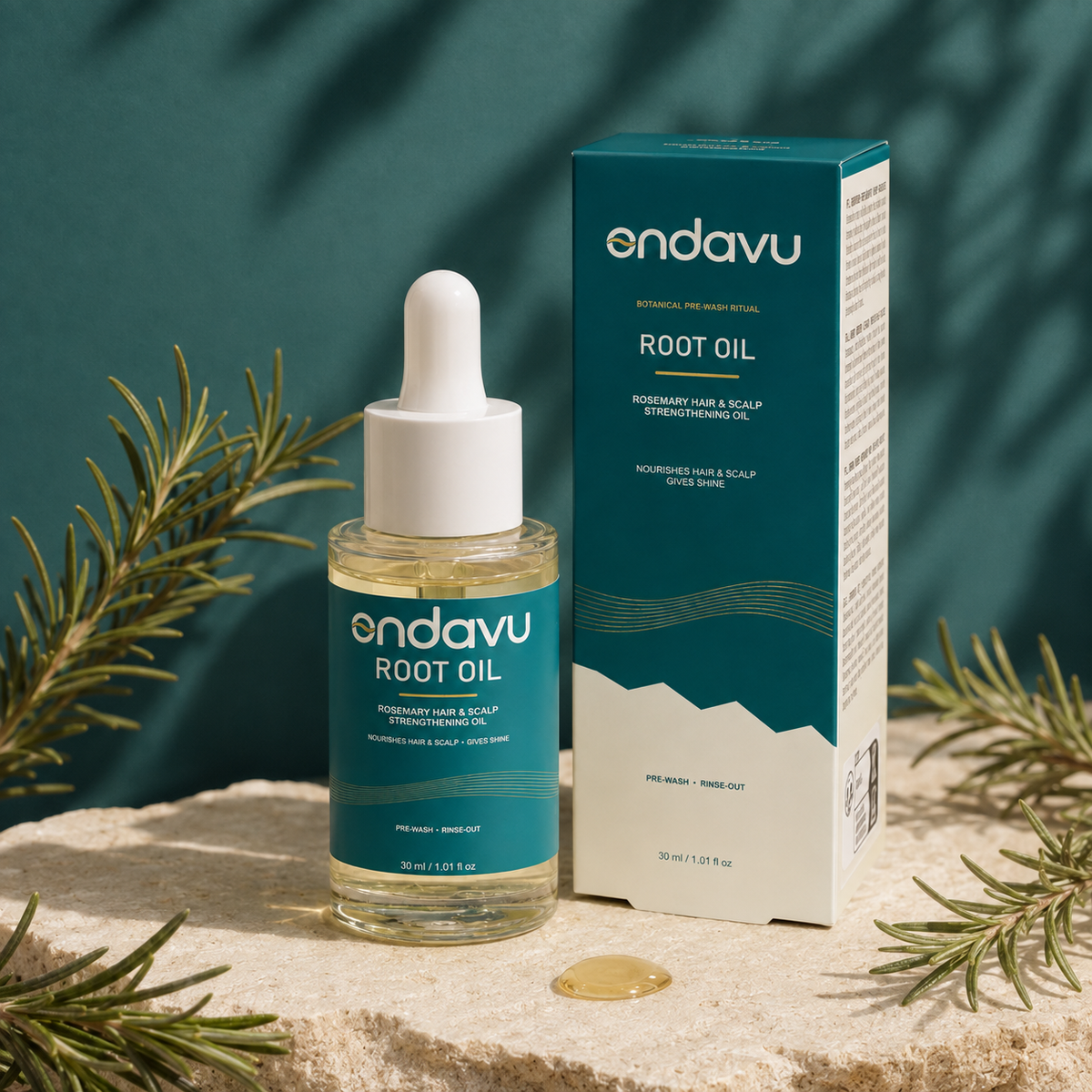 ONDAVU Root Oil bottle and box with rosemary on a deep teal studio set