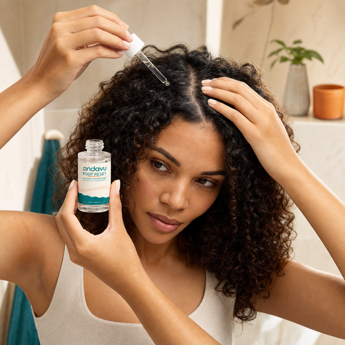 Woman applying ONDAVU Root Reset to a dry scalp part